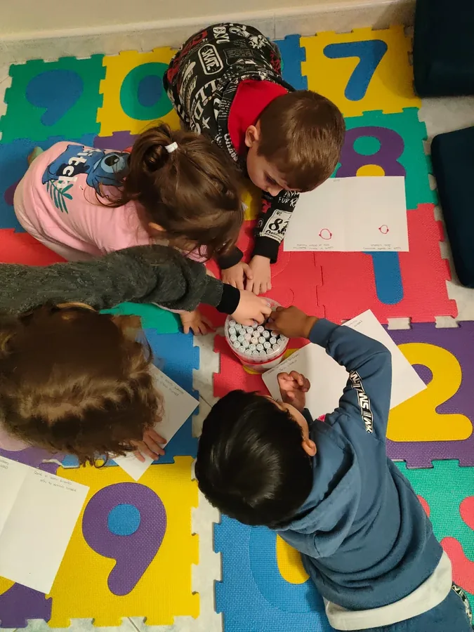 Bambini al lavoro con i pennarelli sul tappeto
