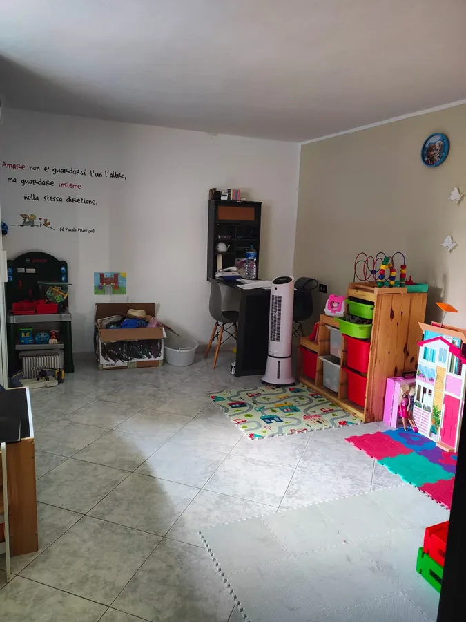 La sala dei giochi con tappeti e scaffali colorati